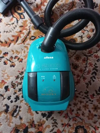 Aspiradora azul con manguera y cepillo