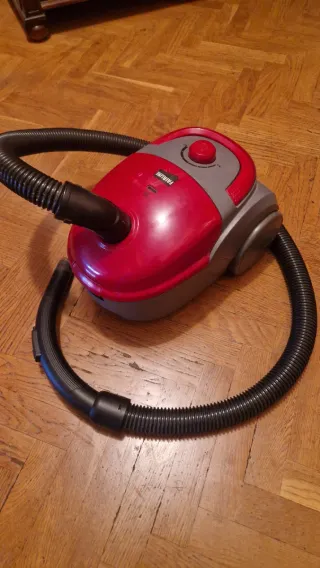 Aspiradora roja y gris con manguera