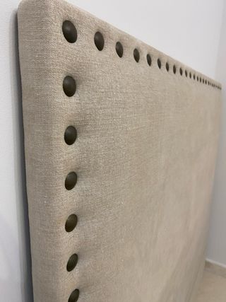 Cabecero de cama beige con tachuelas