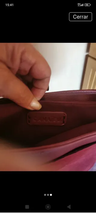 Bolso de hombro burdeos con detalles dorados.