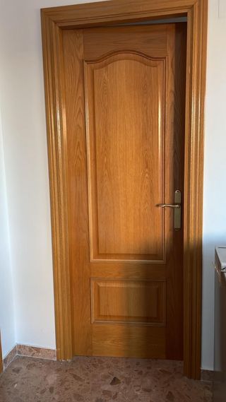 Puerta de madera con marco y manilla