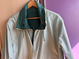 Chubasquero reversible en tomos verdes.