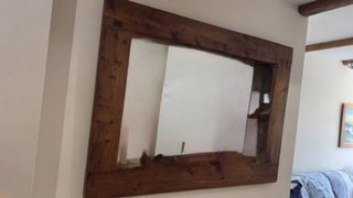 Baúl y espejo rústico de madera y metal.