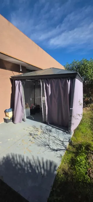Pérgola metálica con cortinas moradas