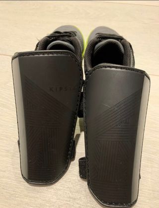 Botas de fútbol y espinilleras grises