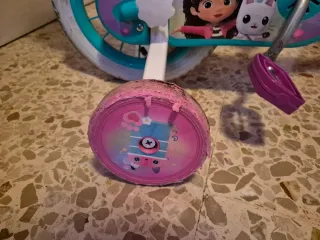 Bicicleta infantil rosa con cesta de Gabby Gato.