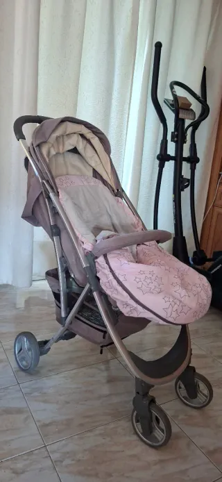 Coche de bebé gris con saco rosa
