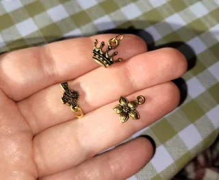 Lote 3 dijes corona, flor, cruz oro