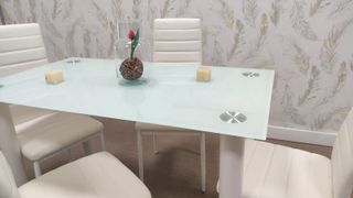 Mesa de cristal con 4 sillas blancas