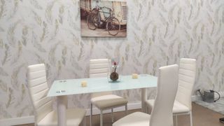 Mesa de cristal con 4 sillas blancas