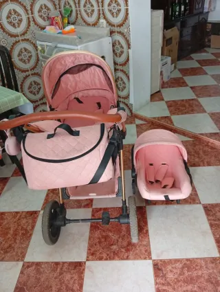 Cochecito de bebé rosa con capazo