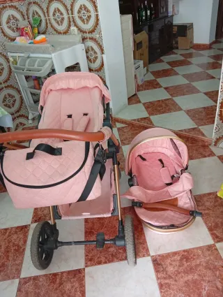 Cochecito de bebé rosa con capazo