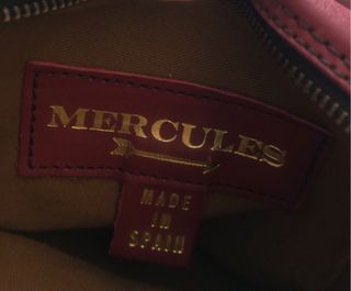 Bolso bandolera granate de piel con flecha dorada.