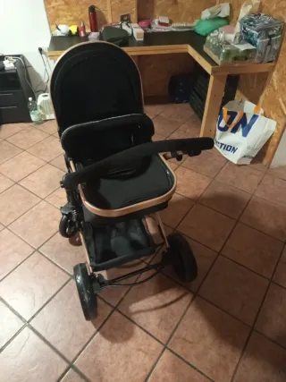 Carro de bebé negro y dorado