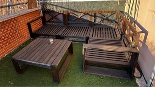 Sofá chaiselonge exterior con cojines y mesa.