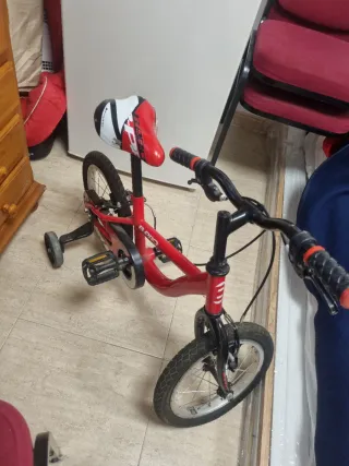 Bicicleta infantil roja con ruedines
