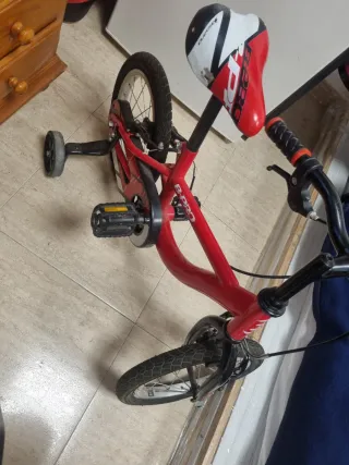 Bicicleta infantil roja con ruedines