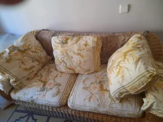 Sofá de mimbre con cojines florales