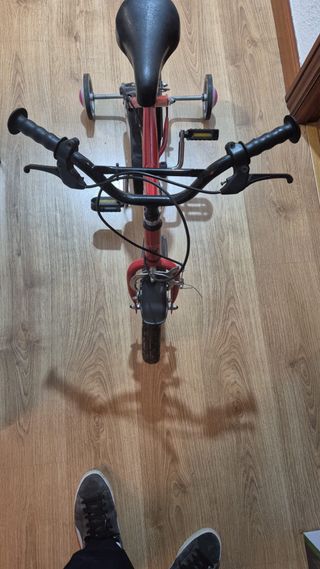 Bicicleta infantil roja con ruedines