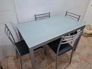 Mesa de cristal y 4 sillas metálicas