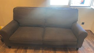 Sofá de tela gris con manta multicolor