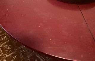 Mesa redonda de madera lacada tono granate