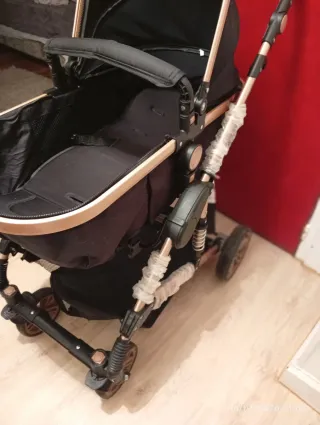 Carro de bebé negro y dorado casi nuevo