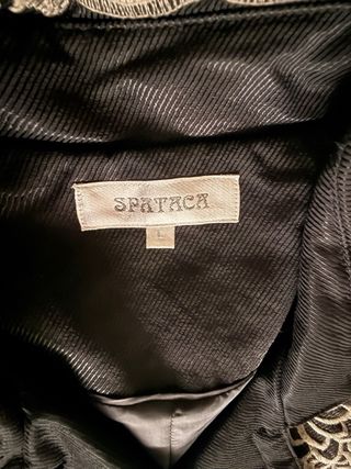 Gabardina negra con bordado beige.