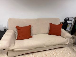 Sofá beige con cojines naranjas