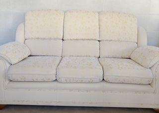 Sofá de tela beige y dorado