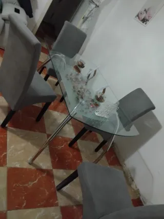 Mesa de cristal con 4 sillas grises