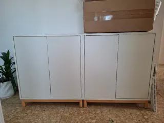 Mueble blanco con patas de madera, con dos puertas