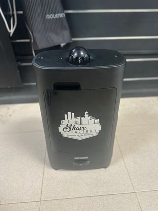 Sillón de peluquería negro y aspirador de pelos