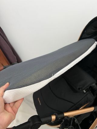 Carrito de bebé negro y dorado con accesorios.