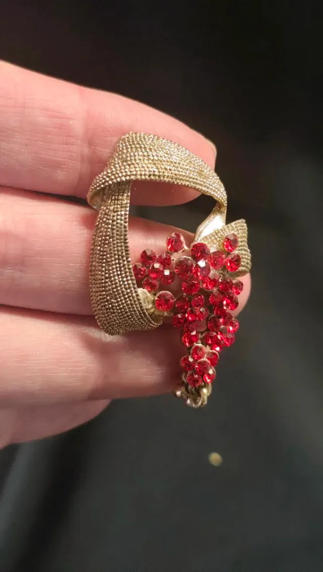 Broche dorado con flores rojas