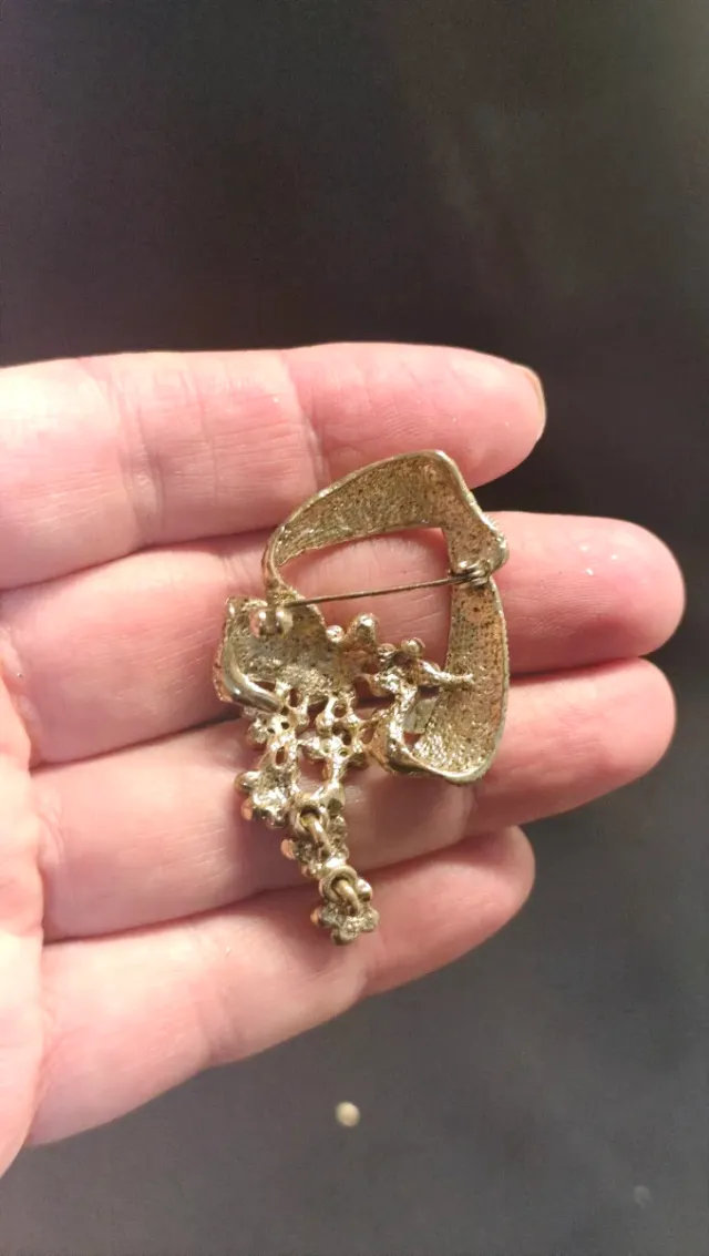 Broche dorado con flores rojas