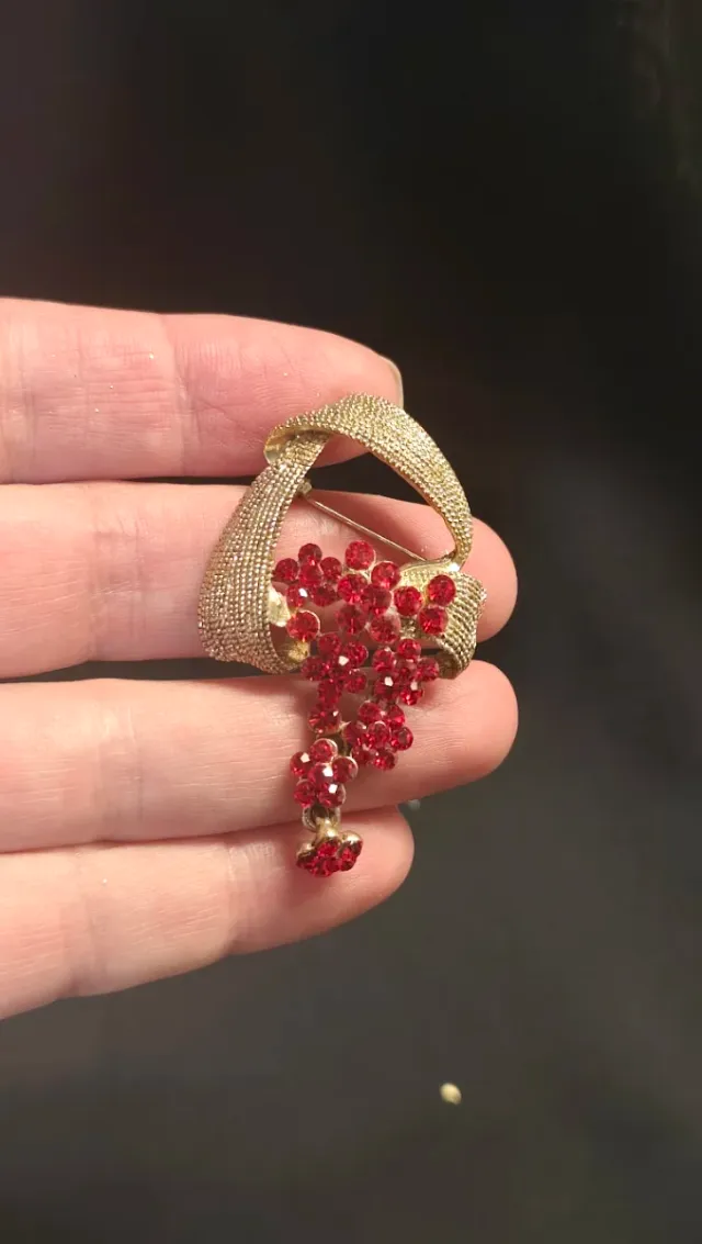 Broche dorado con flores rojas