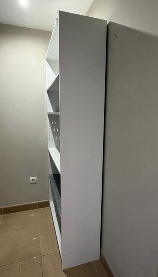 Estantería blanca, con baldas blancas y metálicas.