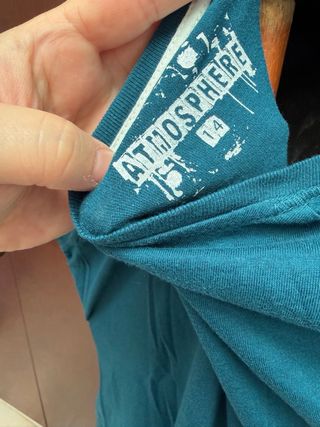 Camiseta turquesa con mancha sonriente