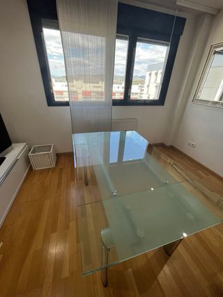 Mesa  de cristal y acero con 6 sillas blancas .