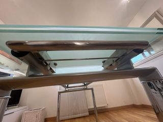 Mesa  de cristal y acero con 6 sillas blancas .