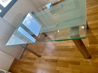 Mesa  de cristal y acero con 6 sillas blancas .