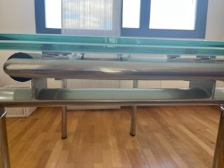 Mesa  de cristal y acero con 6 sillas blancas .