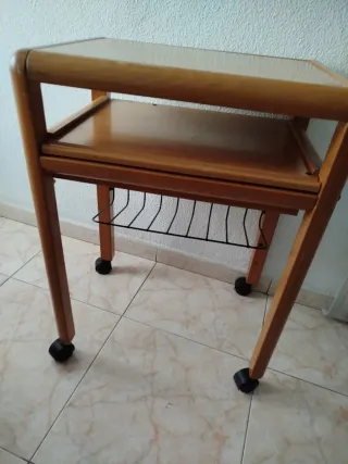 Mesa de ordenador de madera con ruedas y bandejas.