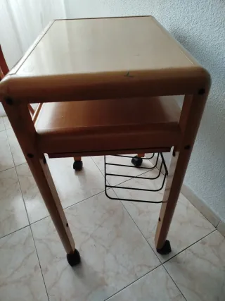 Mesa de ordenador de madera con ruedas y bandejas.