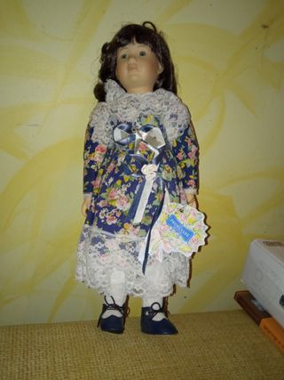 Muñeca de porcelana con vestido floral