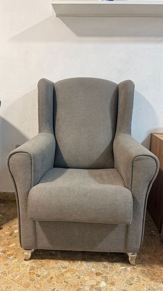 Sillón de tela gris con patas metálicas