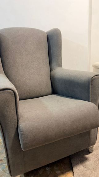 Sillón de tela gris con patas metálicas