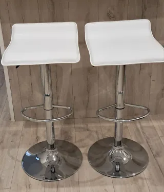Taburetes altos blancos y plateados