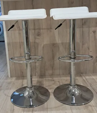 Taburetes altos blancos y plateados